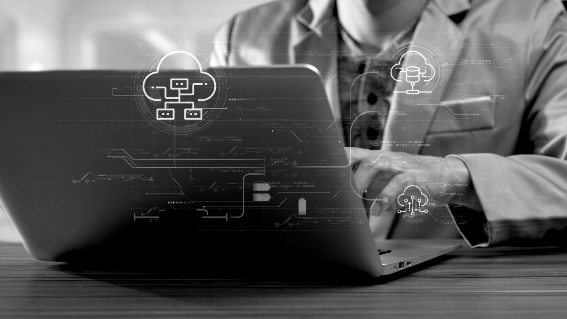 Waggoner - Technology and Collaboration Modernization Close-up of a person working on a laptop with digital cloud and network connection icons overlaid, representing technology and collaboration modernization.